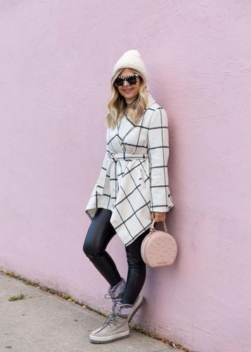 Krystin Lee leaning on pink concrete wall holding pink purse  and Vanetta Suede Mid Boot in Mushroom